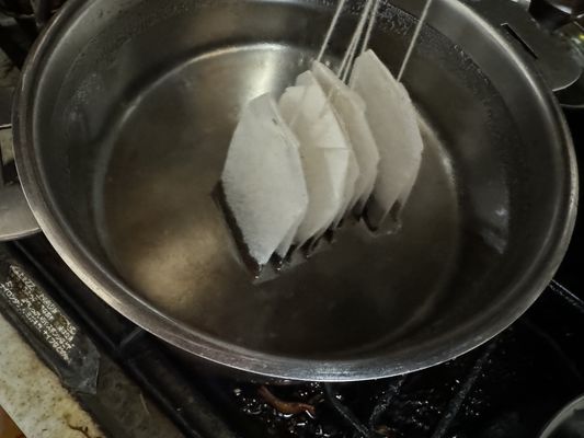 putting tea bag into pan