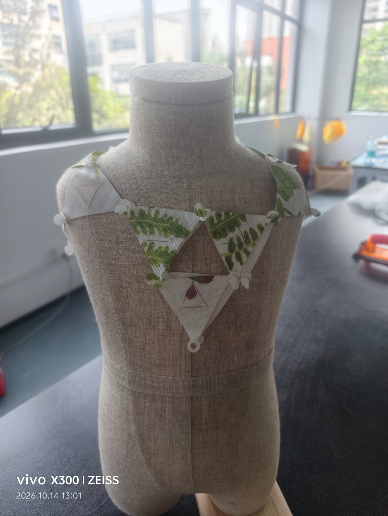 The modular bib worn on the dress form — front view