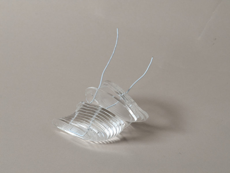 Clear plastic layers separated with white wire passing through them