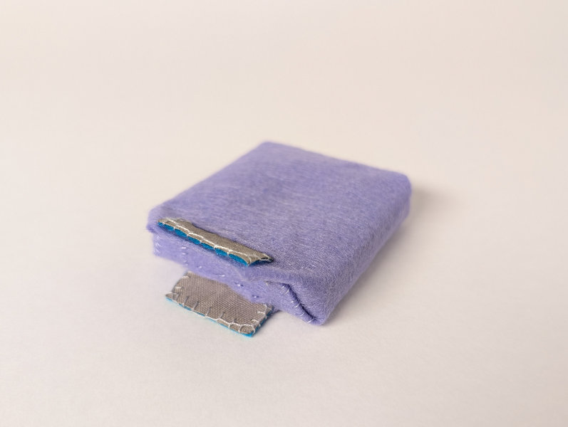 purple felt pouch with silver/blue tabs sticking out of one edge
